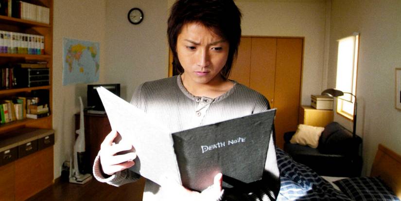 Tatsuya Fujiwara as Light Yagami holding a Death Note in the 2006 live-action film Death Note