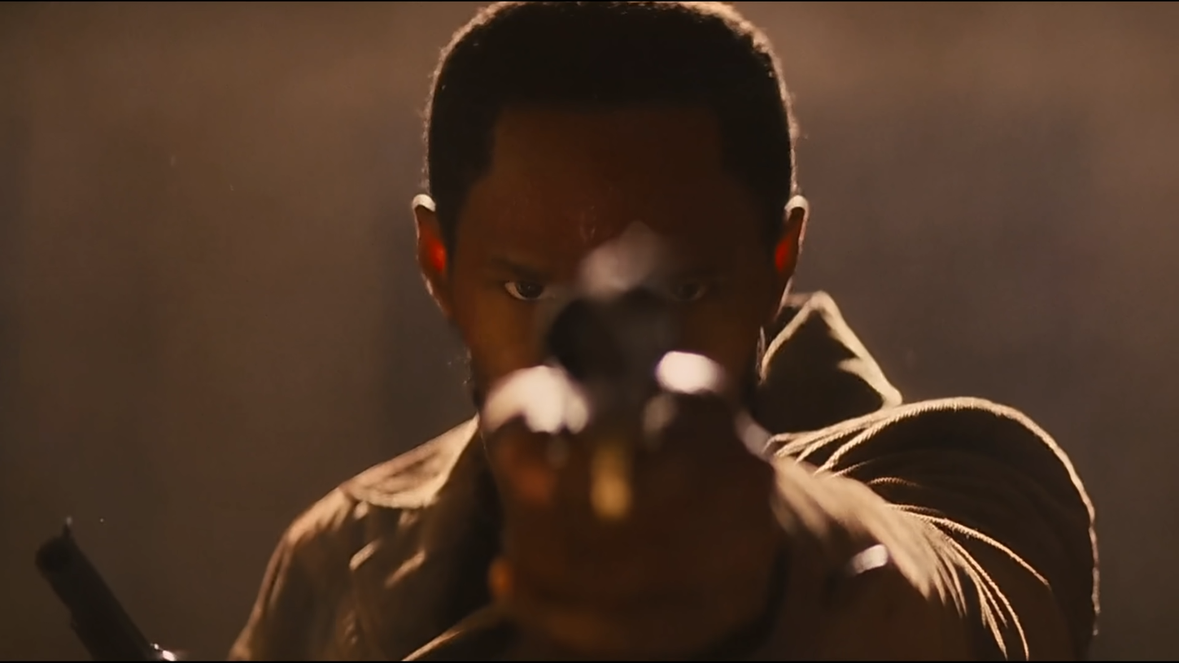 Django pointing one of his revolvers directly at the camera before pulling the trigger during the Candyland shootout in 2012's Django Unchained