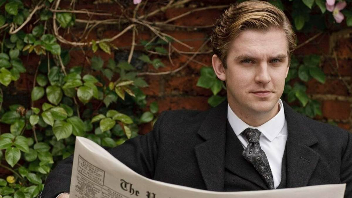 Matthew looking up from reading a newspaper in Downton Abbey