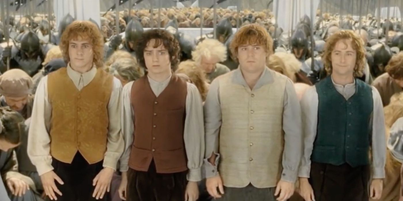 Merry, Frodo, Sam, and Pippin (Dominic Monaghan, Elijah Wood, Sean Astin, Billy Boyd) standing as the royal court bows to them in the ending of The Lord of the Rings: The Return of the King.