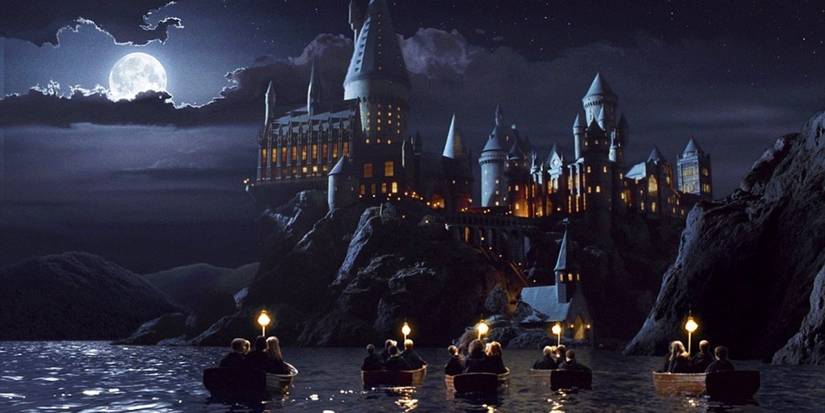 Students ride in boats on their way to Hogwarts in Harry Potter and The Sorcerer's Stone.