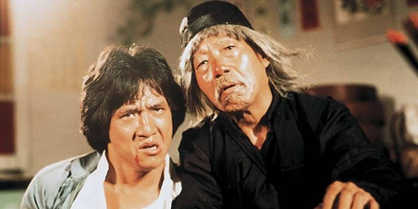 Jackie Chan and Yuen Siu-Tin drunkenly lean on each other and stare at the camera in Drunken Master