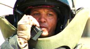 Staff Sergeant William James (Jeremy Renner) wearing a bomb suit and talking into a radio in The Hurt Locker.