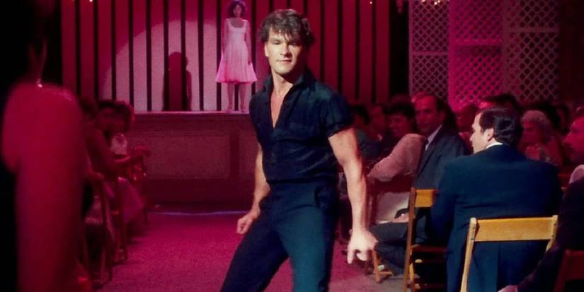 Patrick Swayze as Johnny dancing in the aisles while Baby (Jennifer Grey) watches from the stage in Dirty Dancing