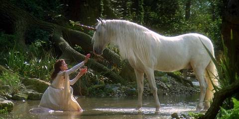 A unicorn waks toward a girl in a forest in Legend
