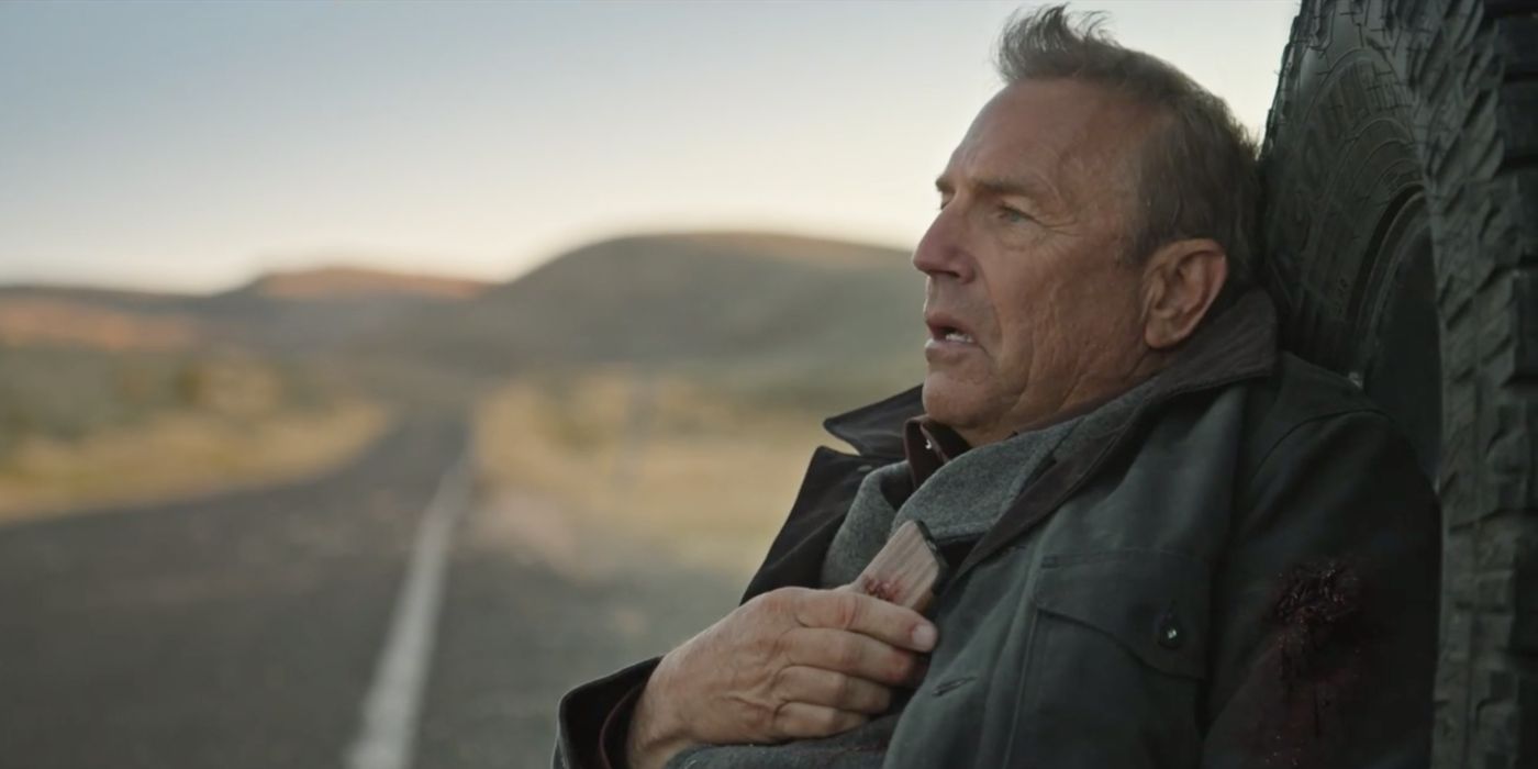 Kevin Costner as John Dutton leaning against a tire Yellowstone.