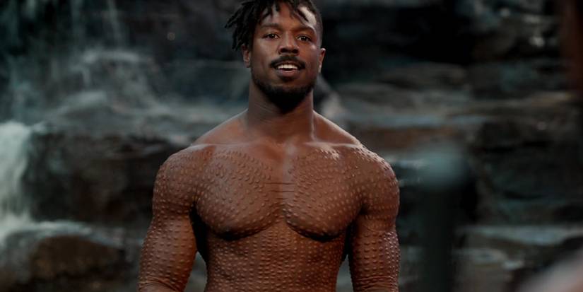 Michael B Jordan as Killmonger, standing bare-chested and looking menacingly during a battle