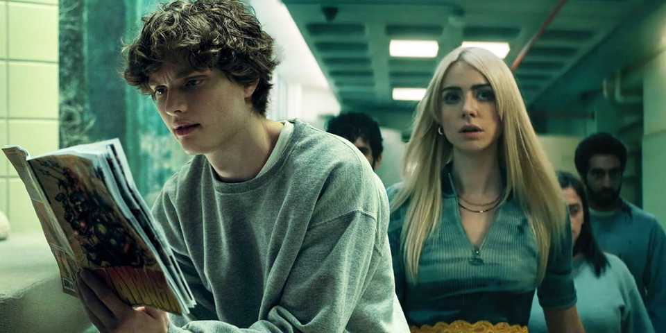 Asa Germann as Sam reading a book and Maddie Phillips as Cate walking down a corridor in Gen V