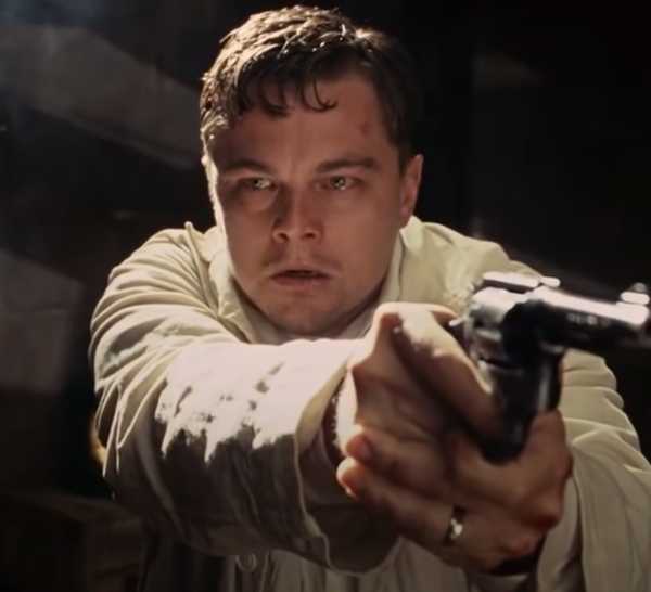 Teddy Daniels (Leonardo DiCaprio) with bloodshot eyes, pointing a gun in Shutter Island
