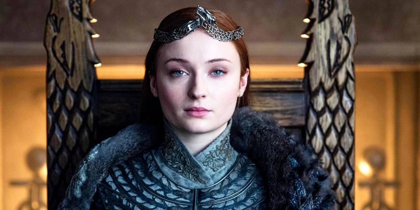 Sophie Turner as Sansa Stark sitting on a thrown with a crown in Game of Thrones