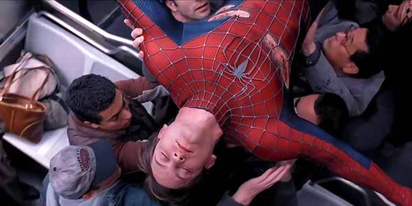 Tobey Maguire as Spider-Man being carried by train pᴀssengers in Spider-Man 2