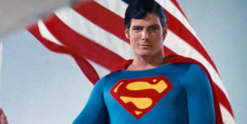 Christopher Reeve como Superman em frente a uma bandeira dos EUA em Superman II