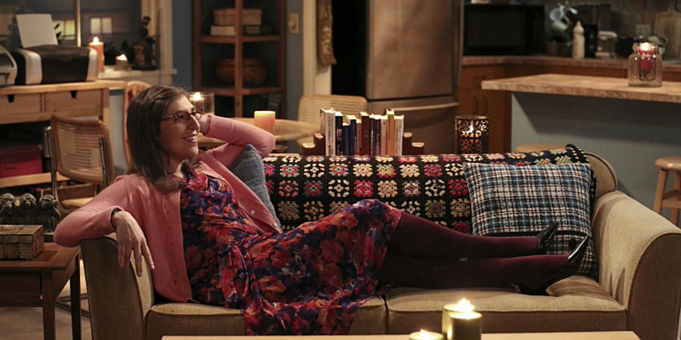 Amy lying on her couch surrounded by candles in The Big Bang Theory