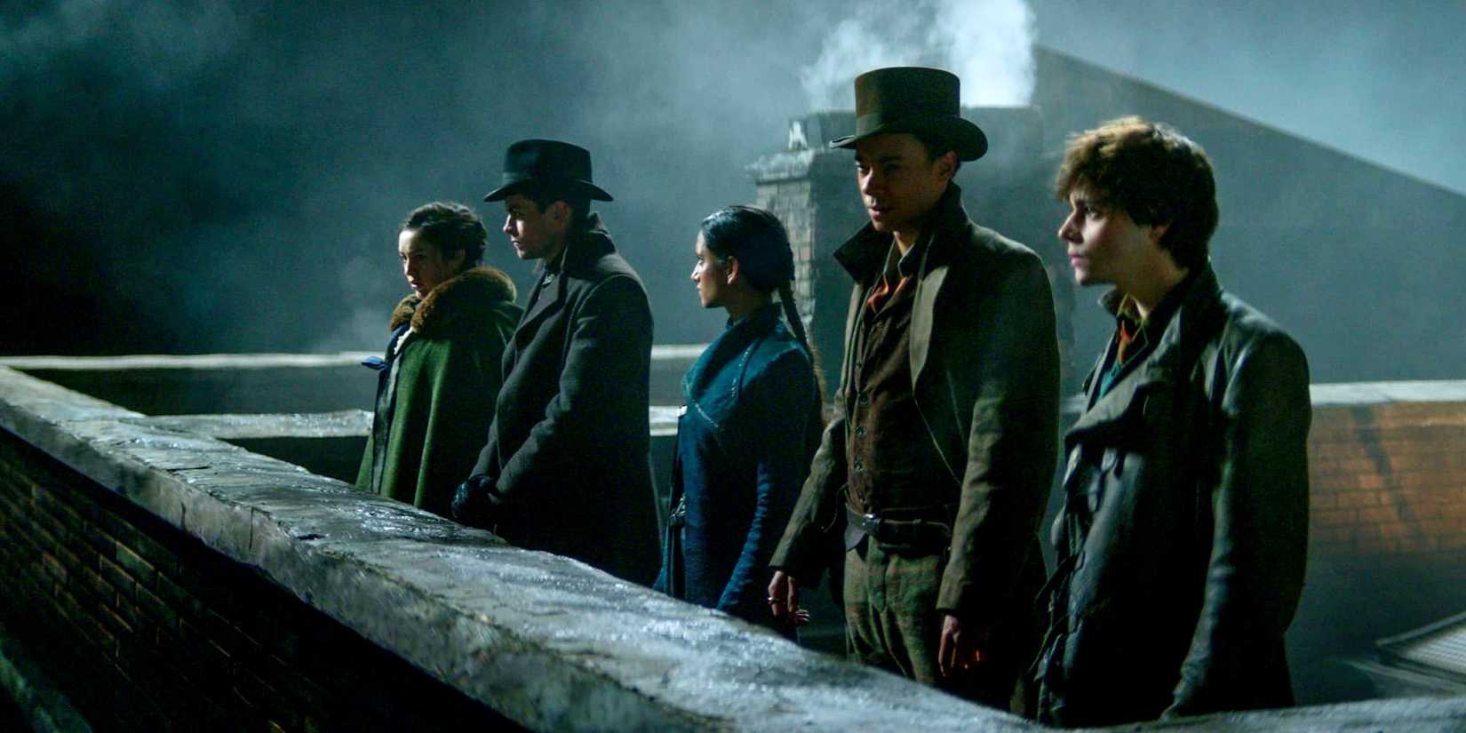 Nina, Kaz, Inej, Jesper, and Wylan standing on a rooftop at night in Shadow and Bone