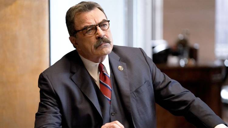 Frank (Tom Selleck) wearing a suit and looking annoyed in Blue Bloods