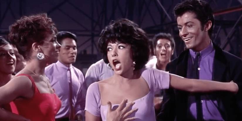 Rita Moreno as Anita gasping with a group of people in "America" in West Side Story