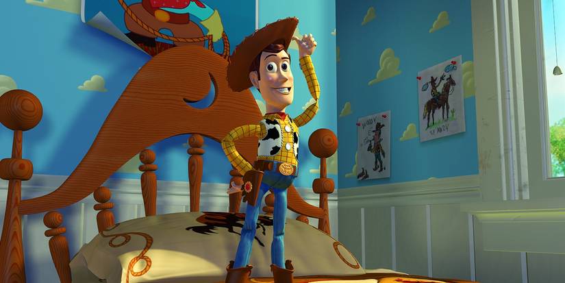 Woody tips his hat while standing on a bed in Toy Story.