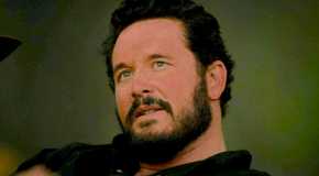 Cole Hauser as Rip Wheeler looking up smugly in Yellowstone.