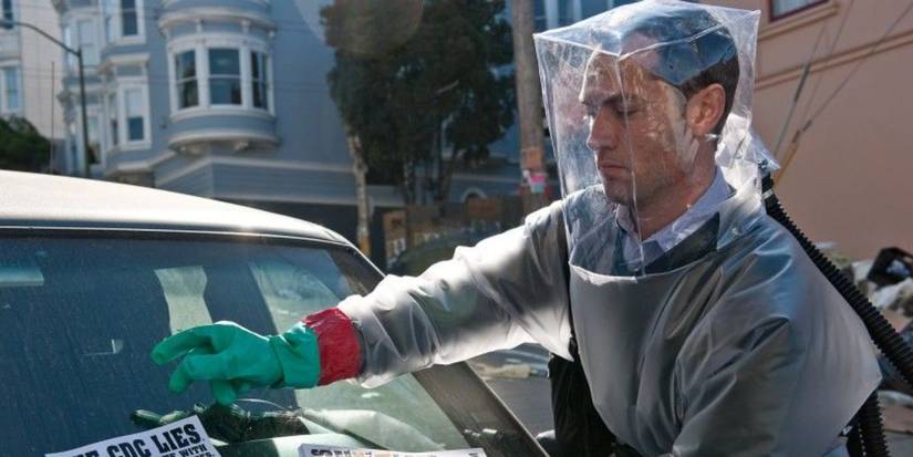 Allan (Jude Law) de Contagion em um traje de Hazmat colocando um panfleto em um para -brisa em contágio