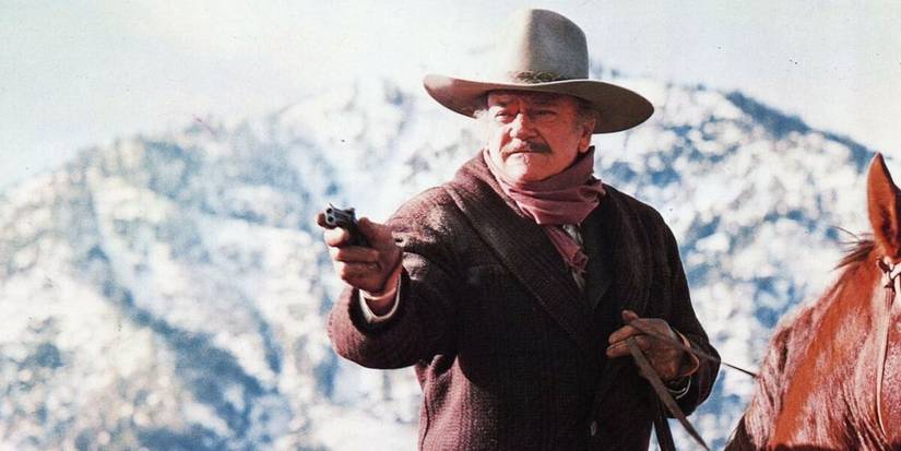 John Wayne como J.B. Books em um cavalo, apontando uma arma em The Shootist.