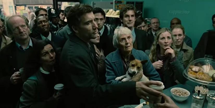 Theo (Clive Owen) dan kerumunan orang berdiri di toko sambil menonton TV di adegan pembuka Children of Men