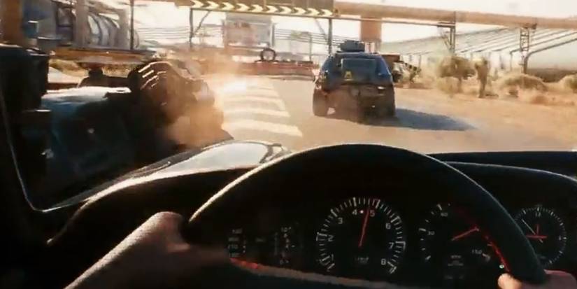 V driving a car in first-person in a race in Cyberpunk 2077.