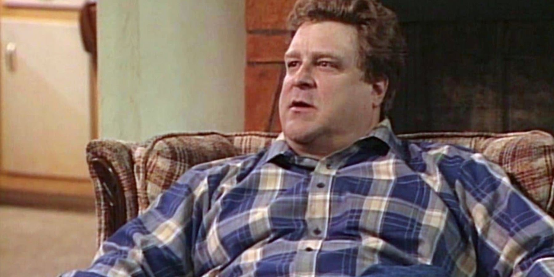 John Goodman as Dan sitting in his chair in the Roseanne episode The Courtship of Eddie