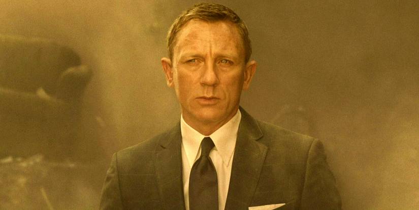 Daniel Craig como James Bond em Spectre usando terno e expressão séria com fumaça atrás dele