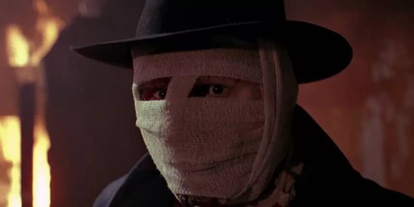 Liam Neeson as Dr. Peyton Westlake in Darkman in front of flames