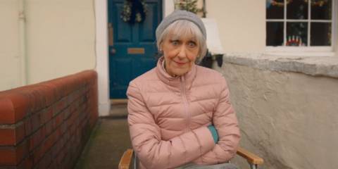 Anita Dobson as Mrs Flood crossing her arms outside her house in Doctor Who.