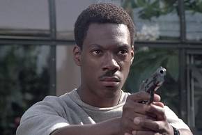 Axel Foley (Eddie Murphy) aims his gun at an off-screen criminal in Beverly Hills Cop.