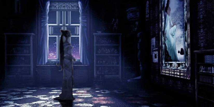 A woman stands in the dark and looks at a painting.