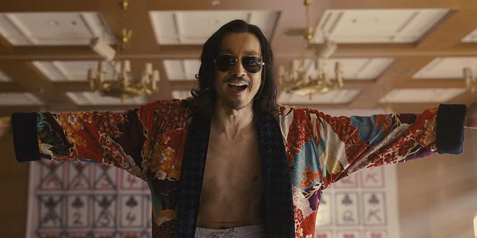 All 10 Alice In Borderland Characters & Their Alice In Wonderland Counterparts Explained The Hatter with his arms outstretched in Alice in Borderland