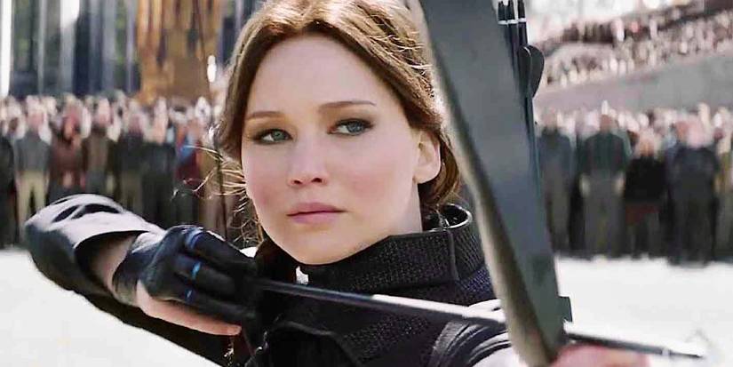 Jennifer Lawrence como Katniss Everdeen mira um arco e flecha nos Jogos Vorazes Mockingjay Parte 2
