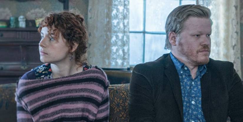 Jake and his girlfriend sitting on the couch looking in opposite direction in I'm Thinking of Ending Things