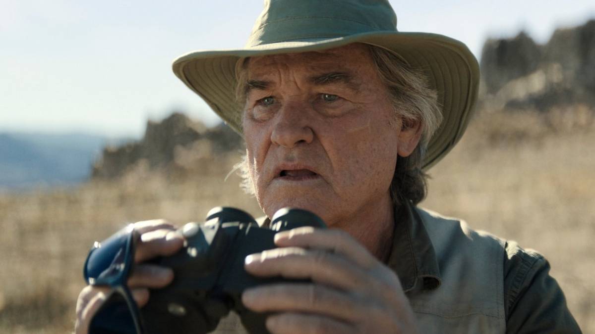 Lee Shaw holds up a pair of binoculars in Monarch Legacy of Monsters