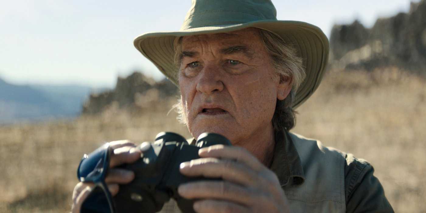 Lee Shaw (Kurt Russell) holds up a pair of binoculars in Monarch Legacy of Monsters