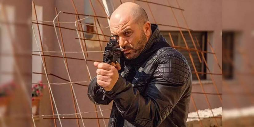 Lior Raz as Doron Kabilio pointing a gun in Fauda.