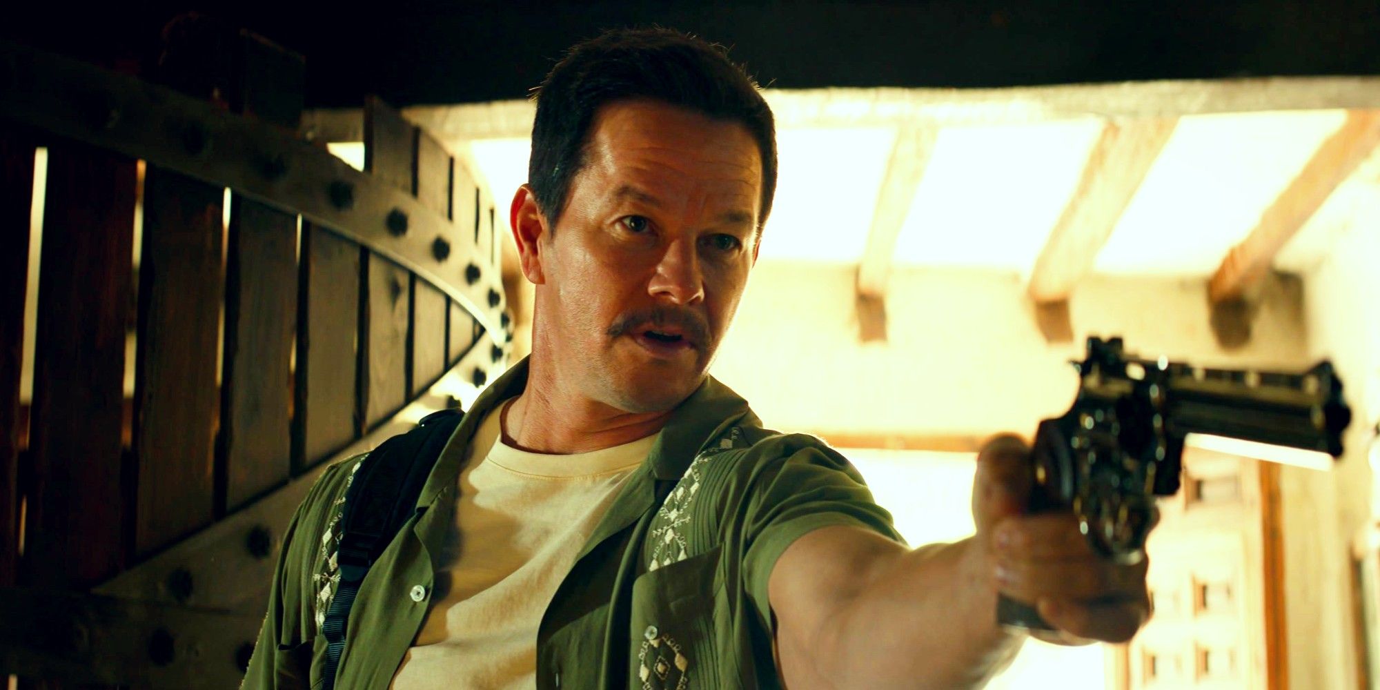 Mark Wahlberg as Victor Sullivan in Uncharted pointing a pistol offscreen