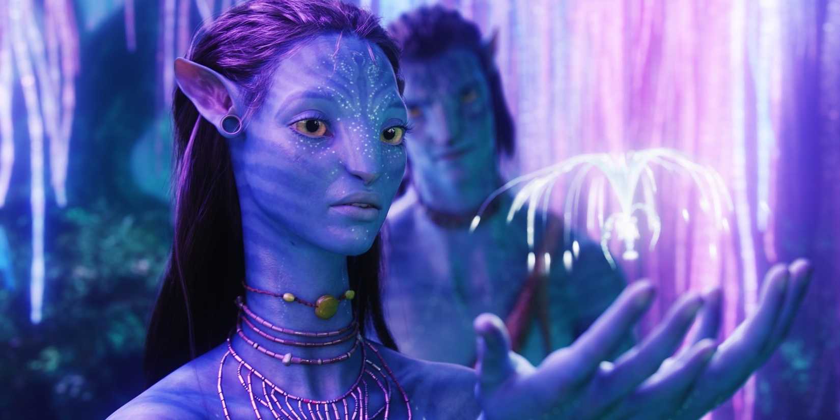 Neytiri (Zoe Saldana) reaches for a woodsprite with Jake (Sam Worthington) at the Tree of LIfe in Avatar