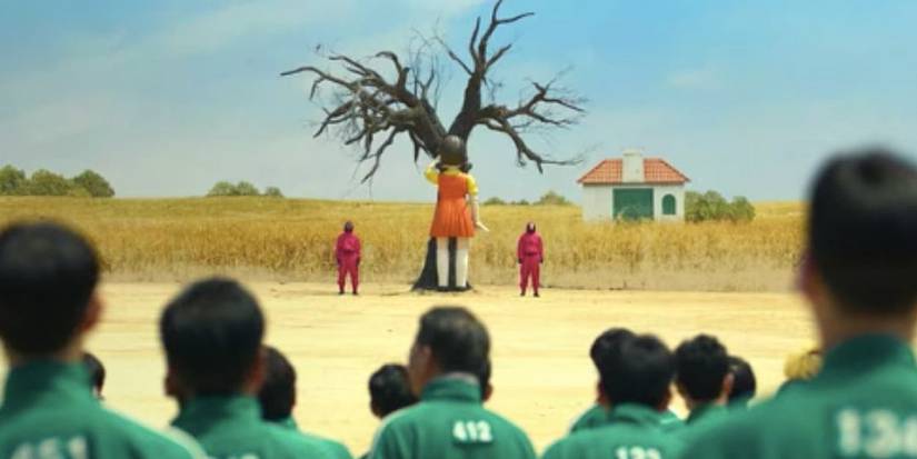 Кукла поет песню "Red Light Green Light" в "Squid Game", пока игроки наблюдают