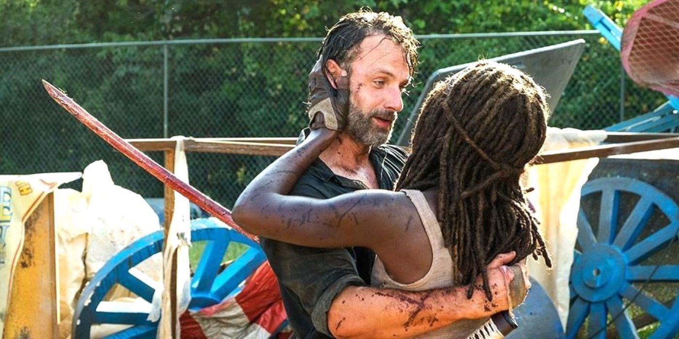 Rick Grimes and Michonne embracing in an abandoned fairground in The Walking Dead