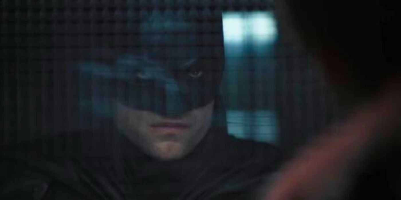 Robert Pattinson looking intensely as Batman at Paul Dano as The Riddler at Arkham Asylum in a scene from The Batman