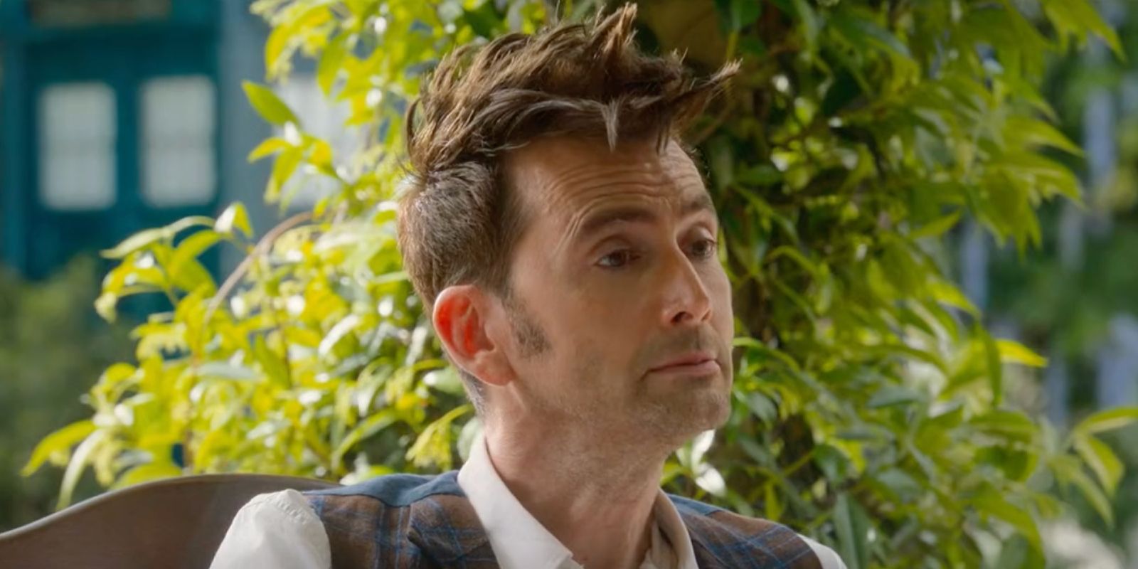 David Tennant as the Fourteenth Doctor sitting and looking satisfied in Doctor Who special episode The Giggle.