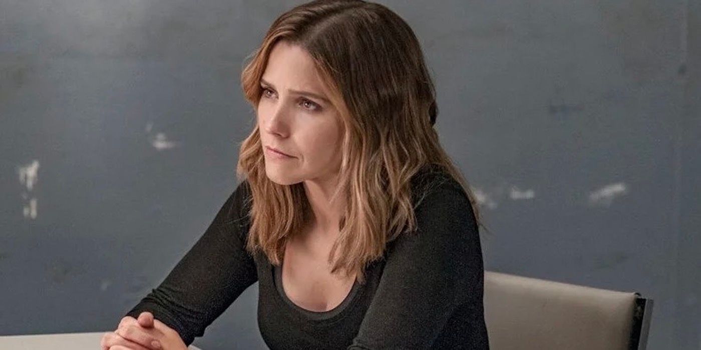 Erin Lindsay sitting at interrogation table with hands interlocked