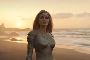 Thena (Angelina Jolie) looks to the side on a beach in The Eternals