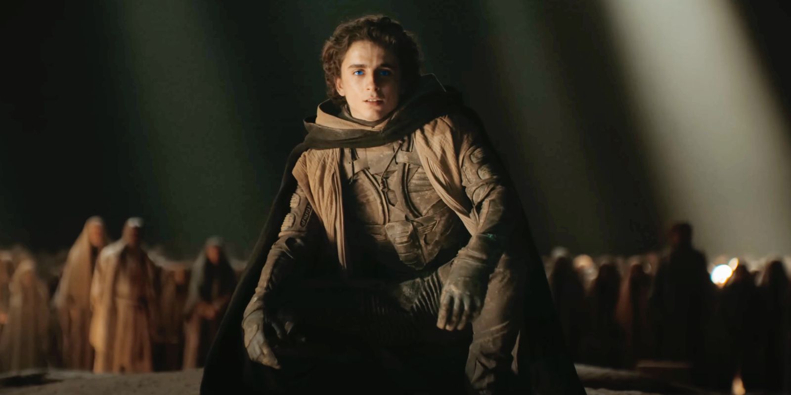 Timothée Chalamet como Paul curvando-se na frente de Fremen em Dune Parte Dois