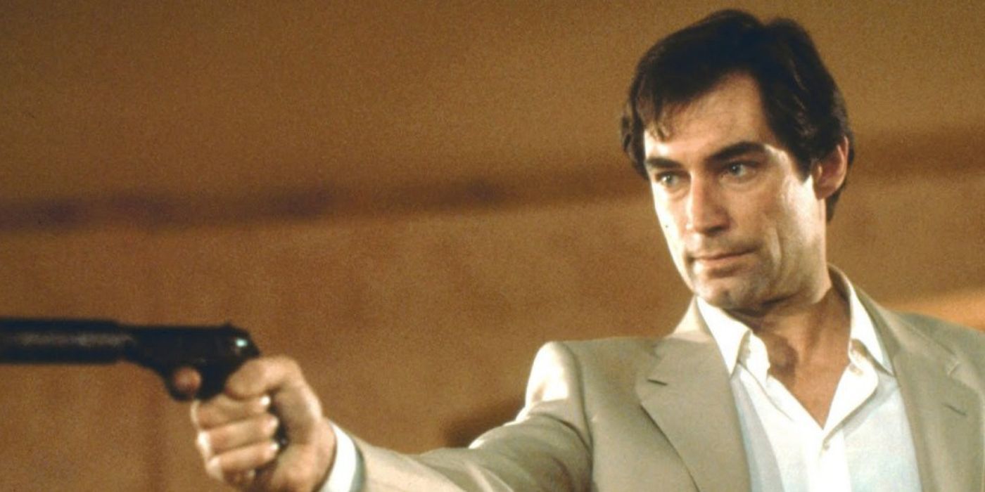 Timothy Dalton as James Bond aims a silenced pistol at someone off-screen in License to Kill.