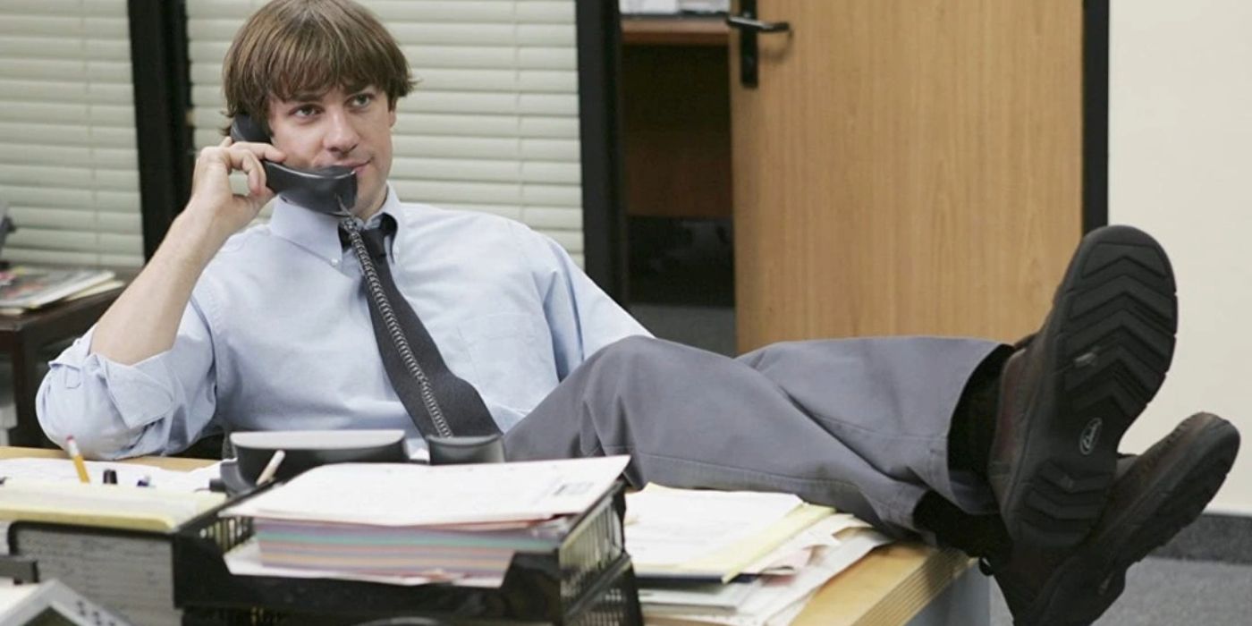 John Krasinski as Jim on the phone with his feet up on the desk in The Office