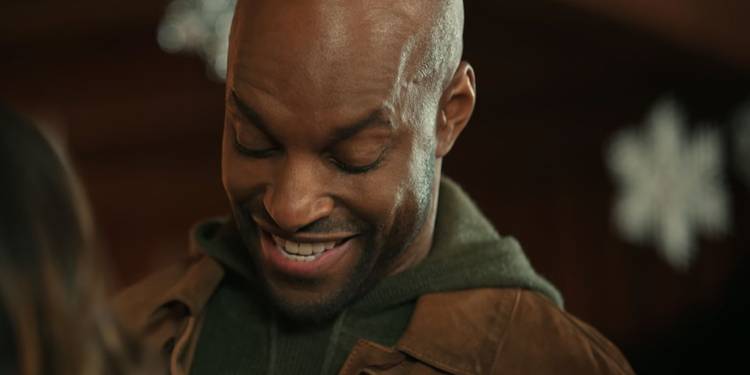 Preacher laughs while talking to Kaia in Virgin River's Christmas episodes